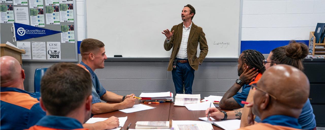 Instructor standing in front of a whiteboard in the classroom